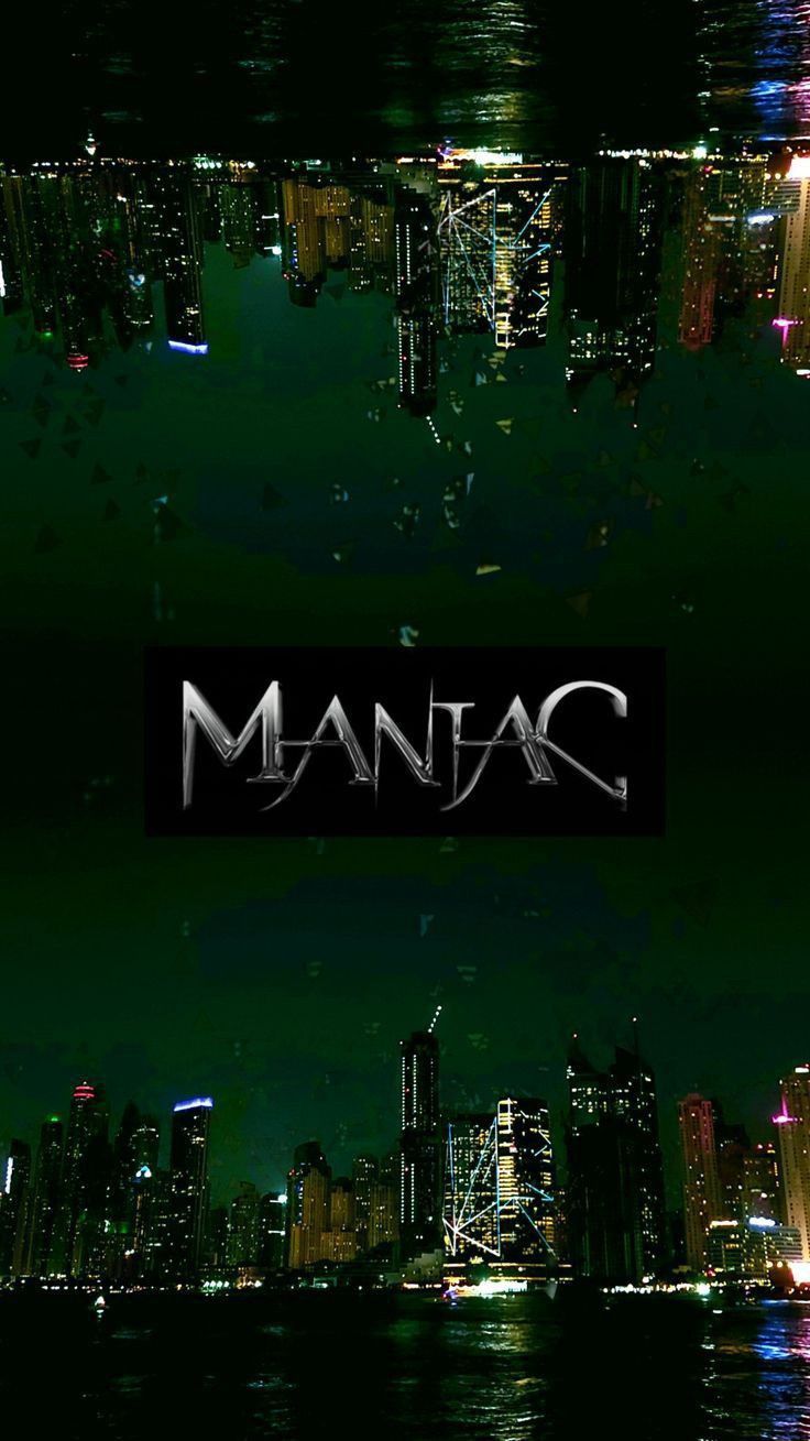 the words mania are lit up in front of a cityscape with skyscrapers