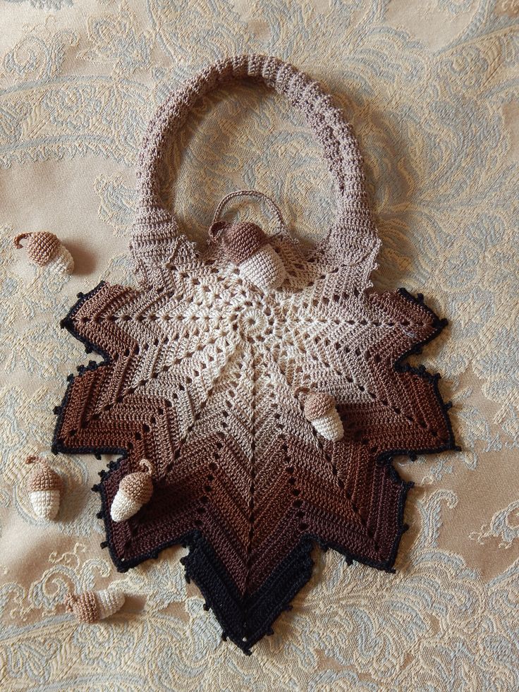 a crocheted purse sitting on top of a bed next to seashells