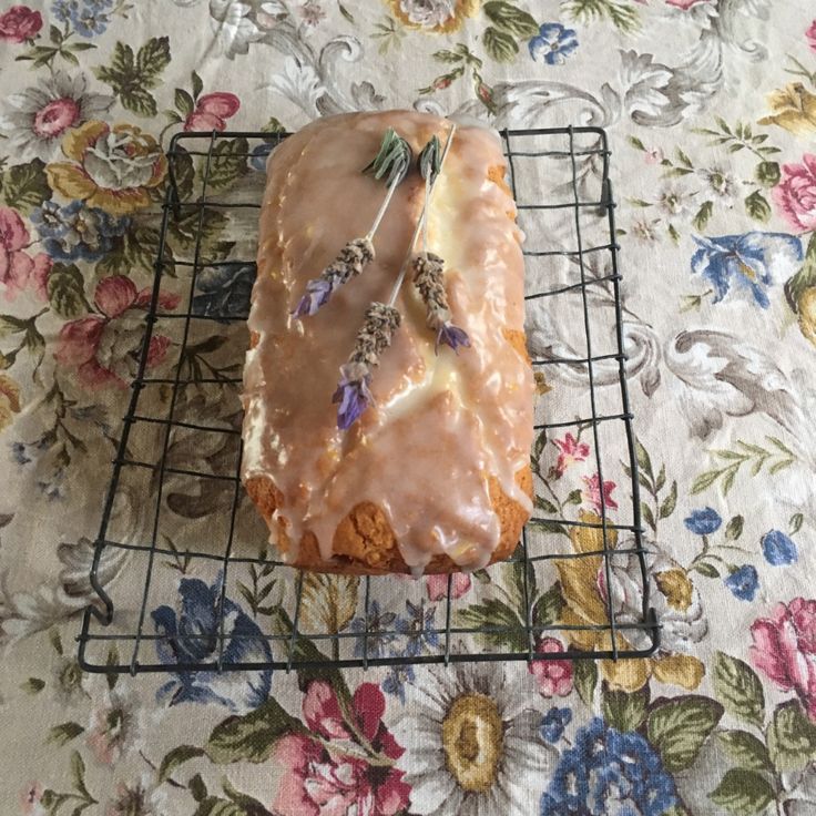 a piece of cake sitting on top of a cooling rack next to a flowery table cloth