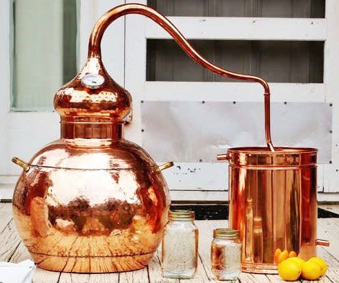 an old copper pot and some lemons on a table