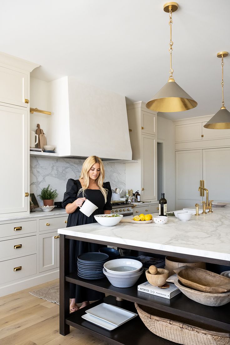 a woman standing in the middle of a kitchen