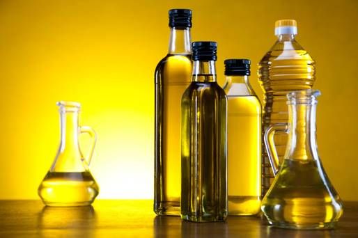 three bottles filled with oil sitting on top of a table