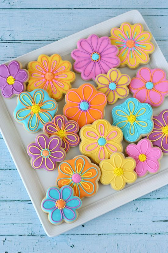 there is a plate full of decorated cookies on the table with color swatches in the background