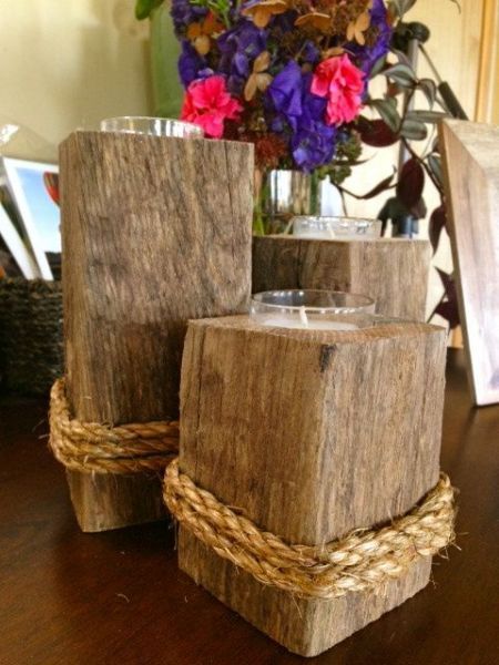 two wooden blocks with rope around them sitting on a table next to a vase filled with flowers