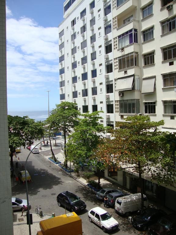 cars parked on the side of a street next to tall buildings with balconies