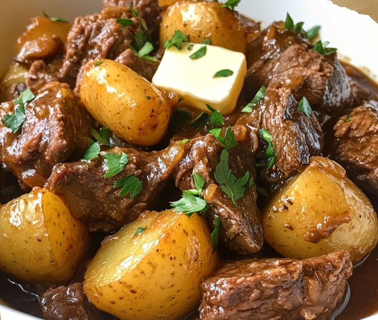 a white bowl filled with beef and potatoes