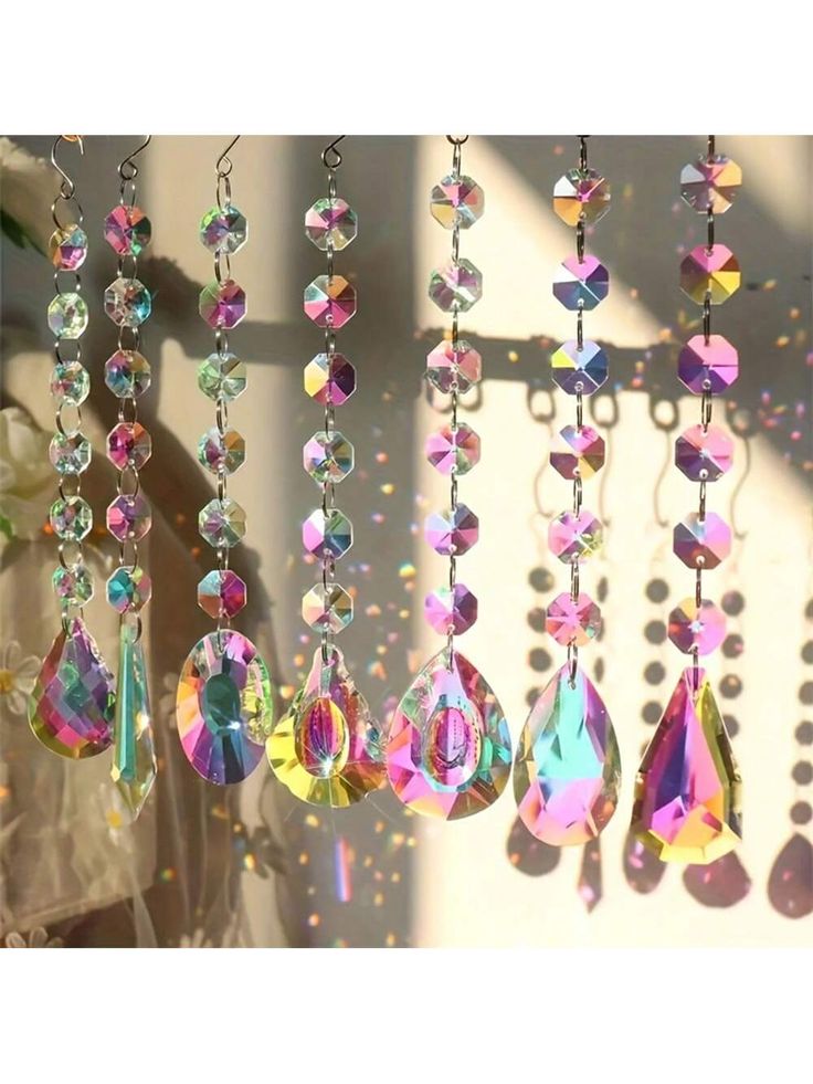 the sun shines brightly through crystal beads hanging in front of a window sill