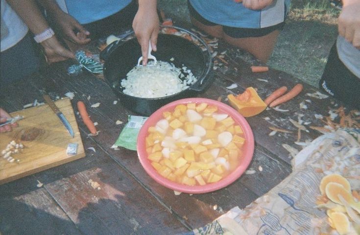 some people are preparing food on a picnic table