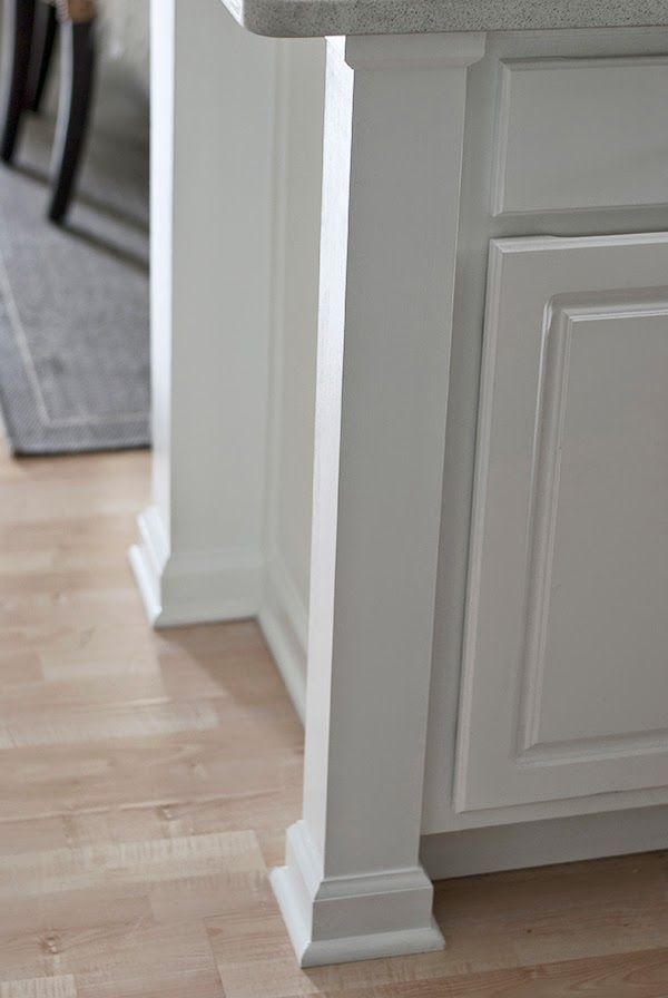 a kitchen with white cabinets and wood flooring on the side of the countertop