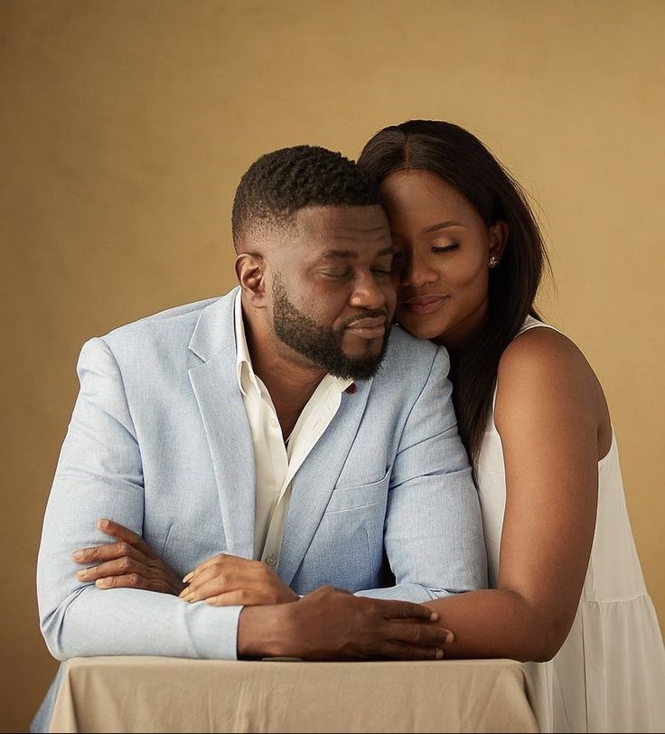 a man and woman embracing each other while sitting at a table