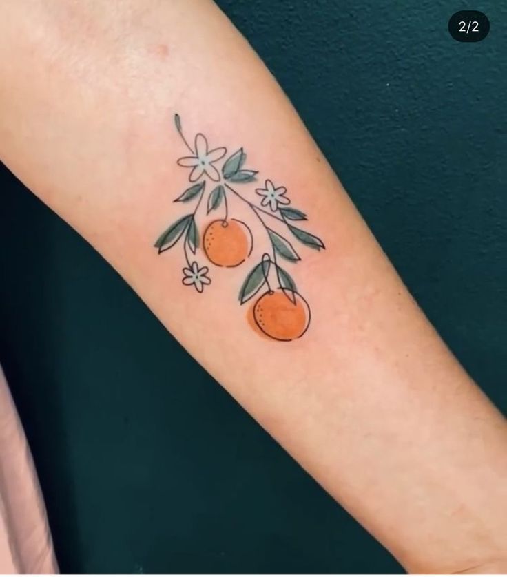 a tattoo with oranges on the arm and flowers around it's branches,