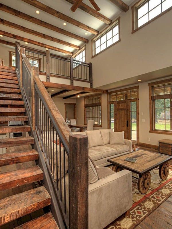 a living room filled with furniture and wooden stairs