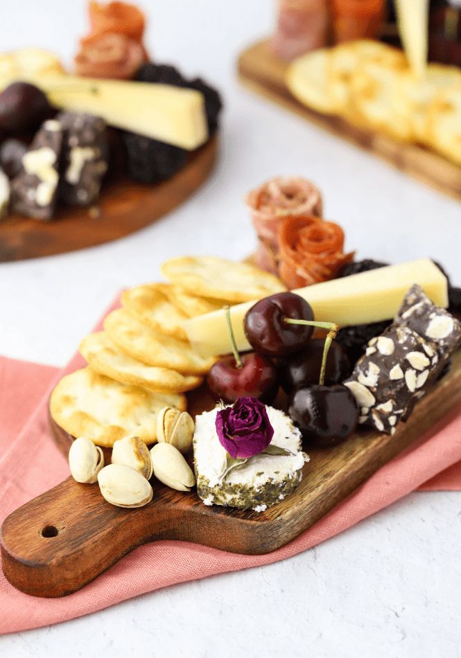 cheese and crackers are arranged on a wooden board