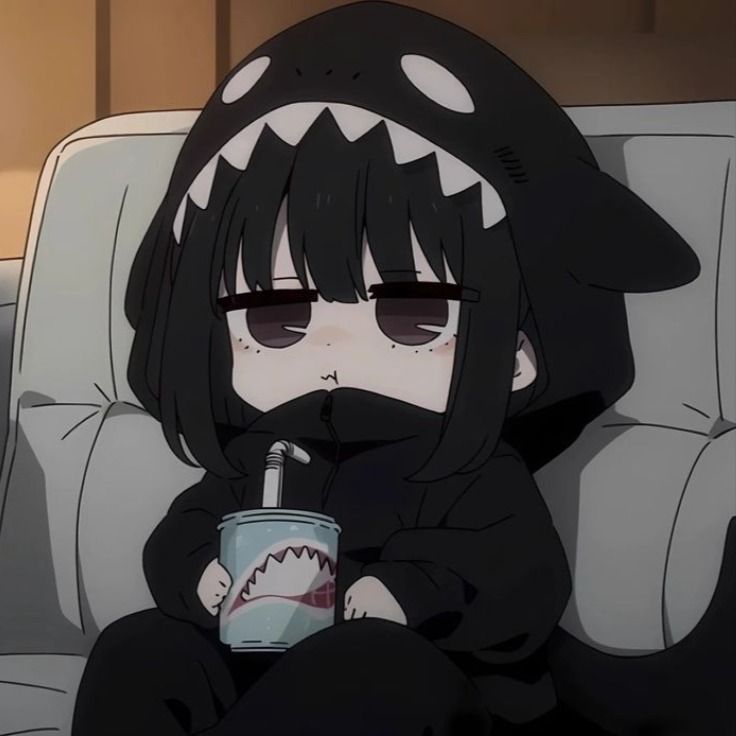 a person sitting on a couch with a cup in their hand and a shark mask on