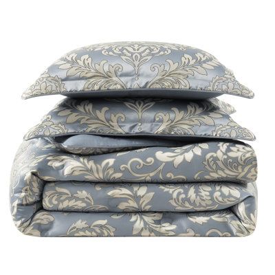 four pillows stacked on top of each other in front of a white background with blue and beige designs