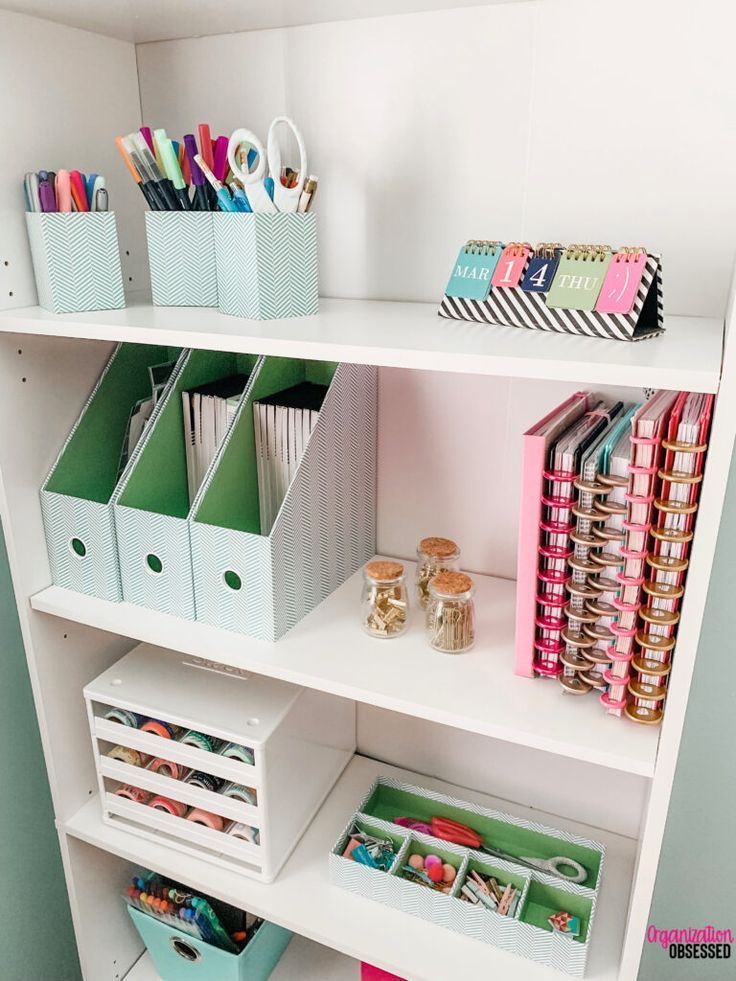 a white book shelf filled with lots of books and crafting supplies on top of it