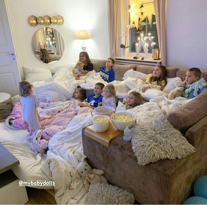 a group of children sitting on top of a couch in a living room next to each other