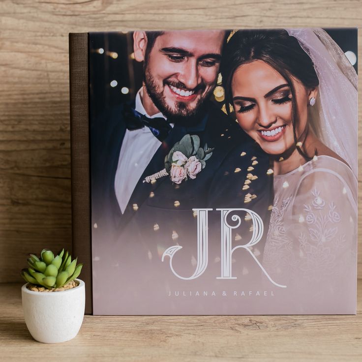 a wedding album sitting on top of a table next to a succulent plant