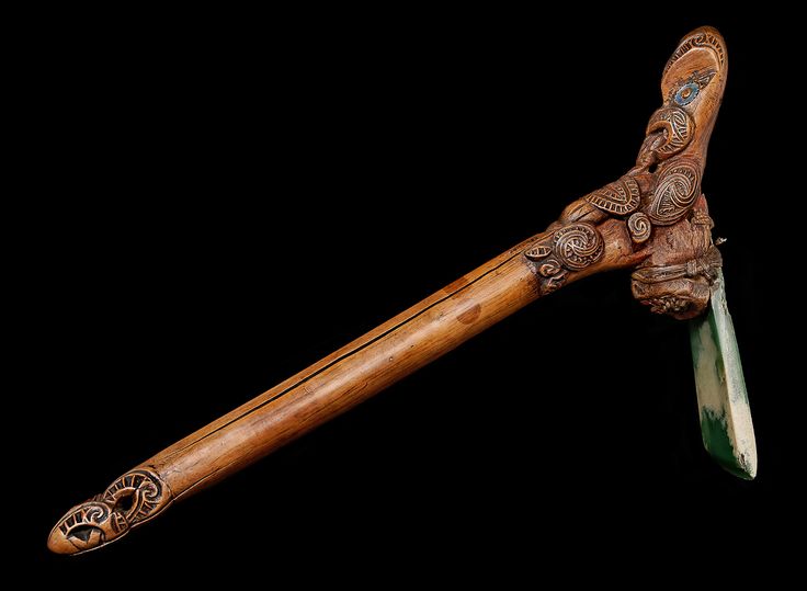 an ornate wooden handle with intricate carvings on it and a green blade in the middle