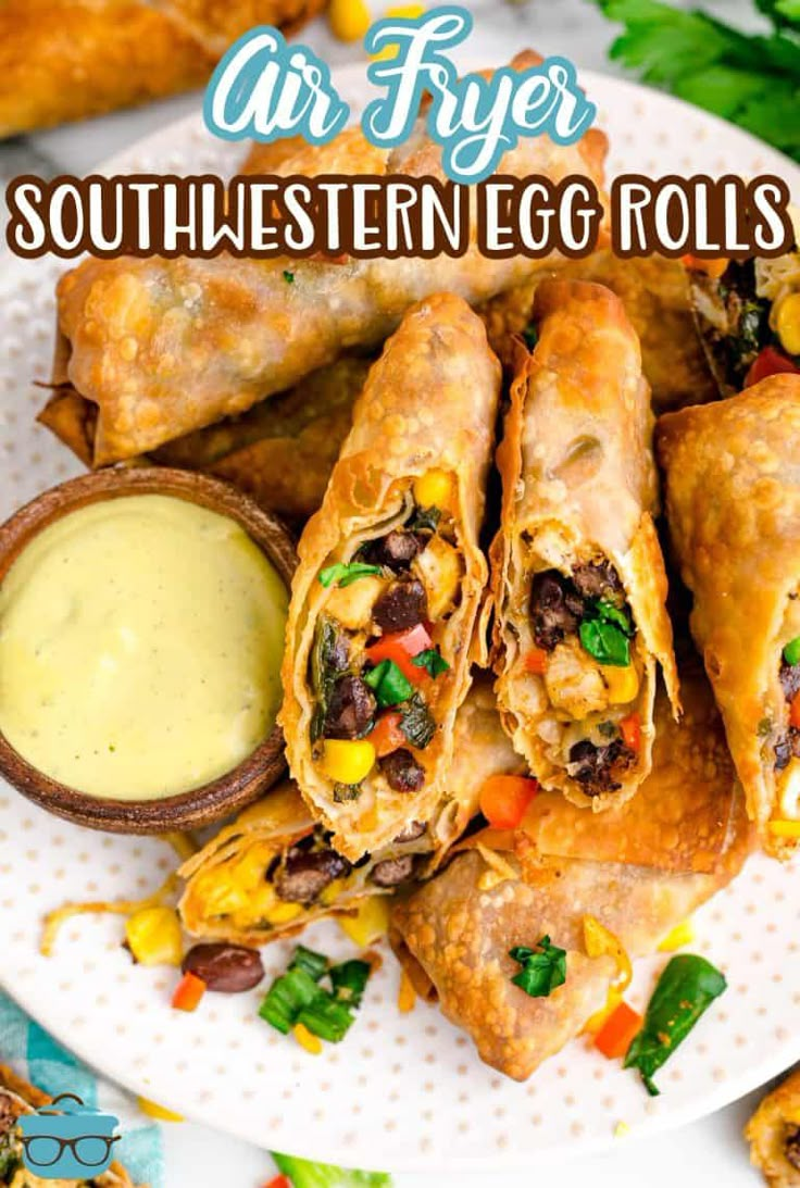 air fryer southwestern egg rolls on a white plate with dipping sauce in the middle