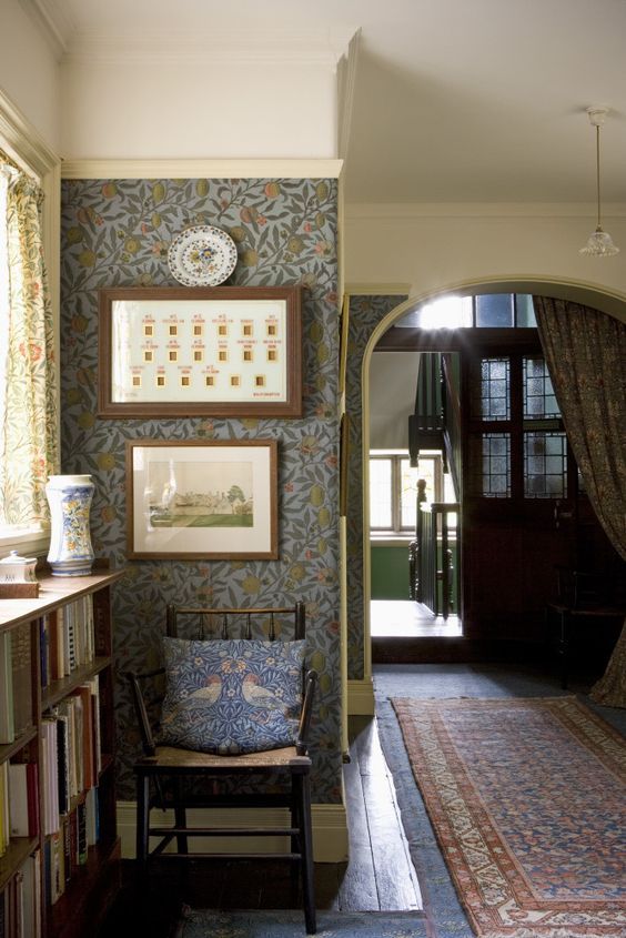 a room with a chair, rug and pictures hanging on the wall next to bookshelves