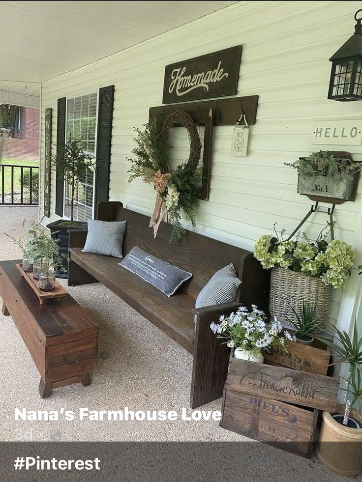 a porch with potted plants and wooden benches