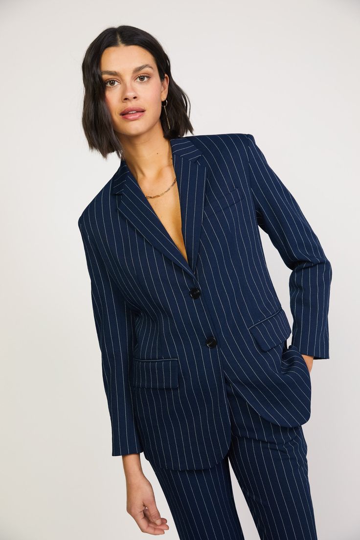 This navy blazer nods to classic menswear tailoring with a structured silhouette in delicate pinstripes. The single-breasted jacket features a smart cut and timeless details: notched lapels, flap pockets, and a vented back hem to ease the fit. •Padded shoulders •Notched lapels •Welt pocket at chest •Button closures at front DIMENSIONS •Standard: 18" Length Item number 2220097 100% Polyester Hand Wash Cold Indigo Suits Women, Pinstripe Blazer, Elegant Blazers, Single Breasted Blazer, Blazer Beige, Blazer Designs, Corduroy Blazer, Navy Blazer, Single Breasted Jacket