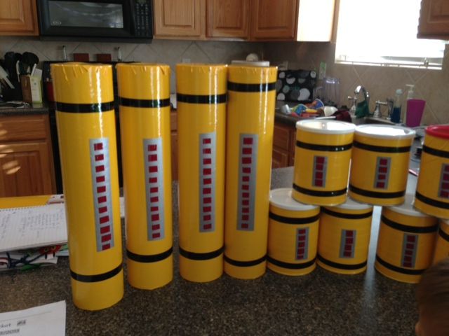 many yellow cylinders are stacked on top of each other in a kitchen area with wooden cabinets