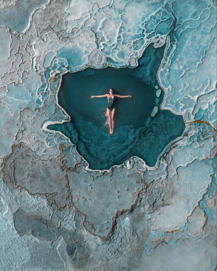 a woman floating in the middle of blue water