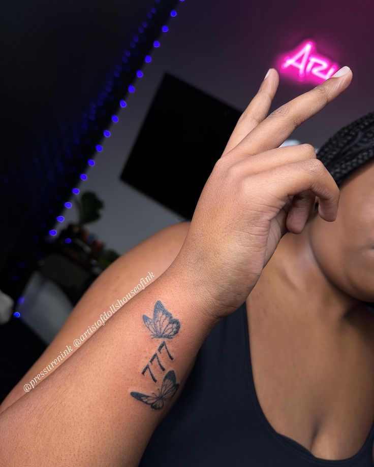 a woman with a tattoo on her arm making the peace sign