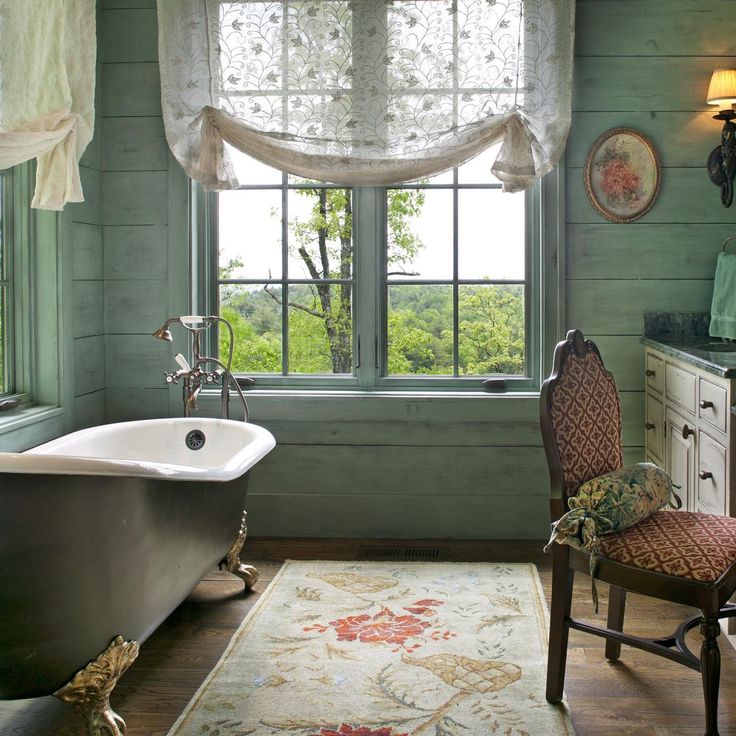 a bathroom with a tub, chair and window