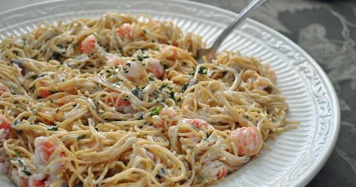 a white plate topped with pasta and shrimp