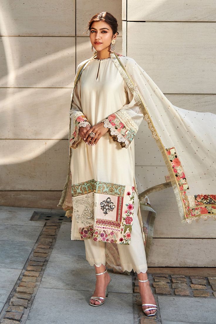 Ivory chanderi kurta enhanced with patchwork embroidered panel. Paired with ivory chanderi trousers and a georgette dupatta accentuated with mukaish, lace and patchwork border.
Component: 3
Pattern: Embroidered
Type Of Work: Patchwork
Neckline: Loop Keyhole Neck
Sleeve Type: Long Sleeves
Fabric: Kurta and Trouser-Chanderi, Dupatta-Georgette
Color: White
Other Details: 
Embroidered dupatta
Loop neckline
Scallop borders
Occasion: Wedding - Aza Fashions Varun Bahl, Georgette Tunics, Georgette Dupatta, White Kurta, Keyhole Neck, Kurta With Pants, Kurta Set, Embroidery Details, Festival Wear