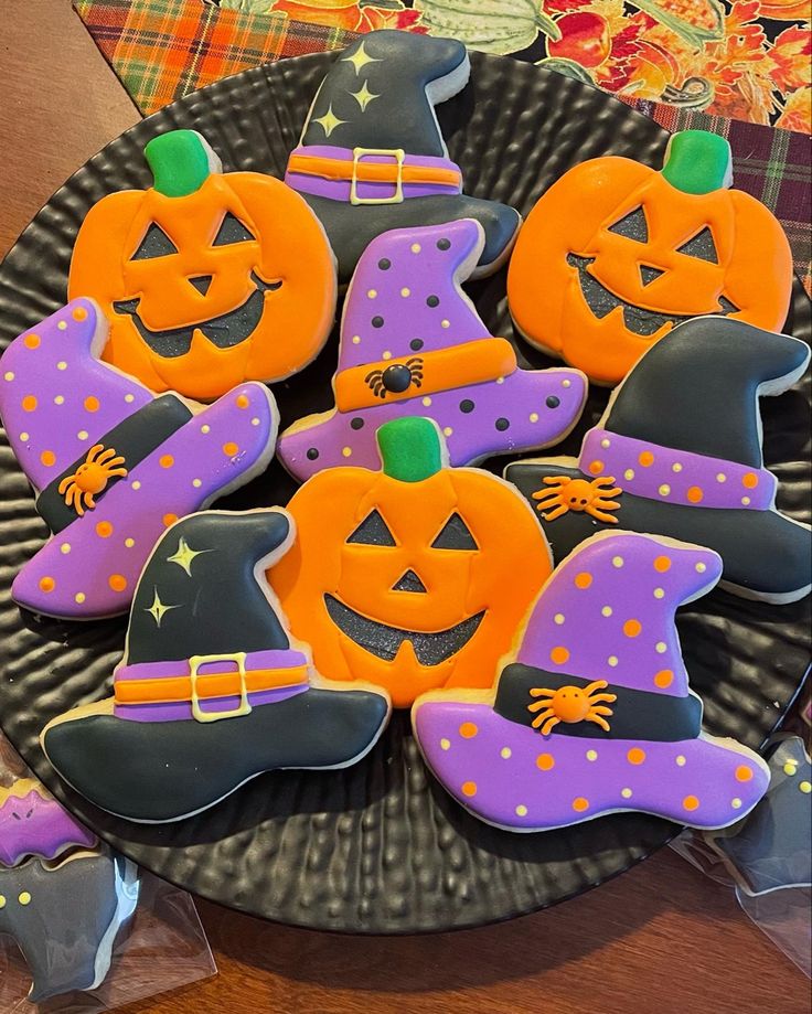 decorated cookies in the shape of witches and pumpkins on a plate with other decorations