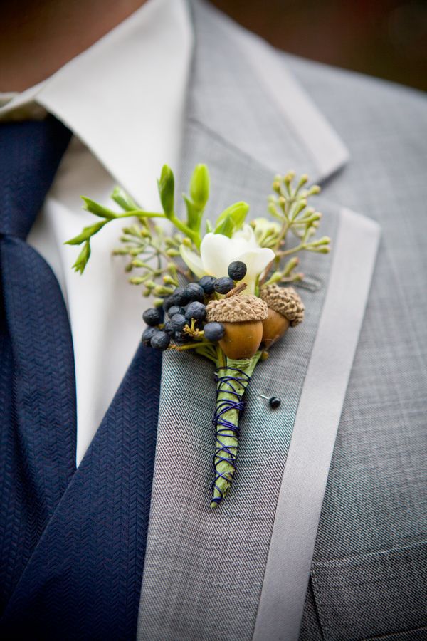 a man wearing a suit and tie with a boutonniere on his lapel