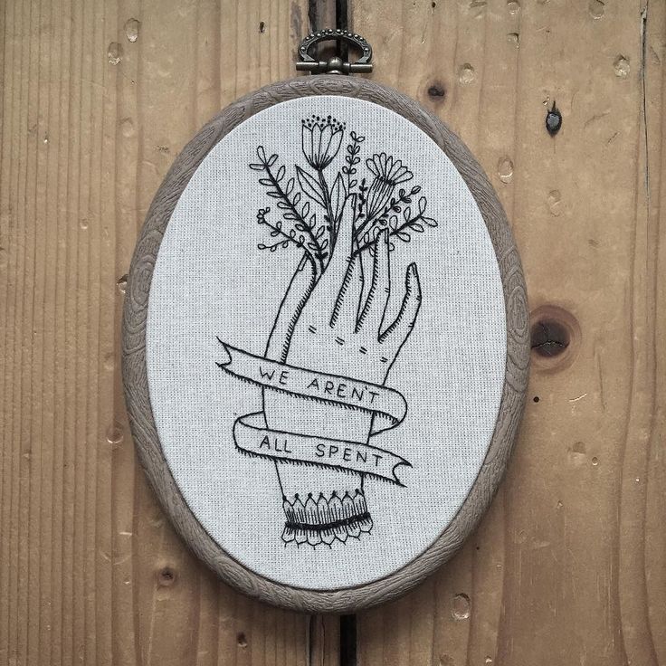 an embroidered wall hanging with a hand holding flowers on it and the words we aren't are silent