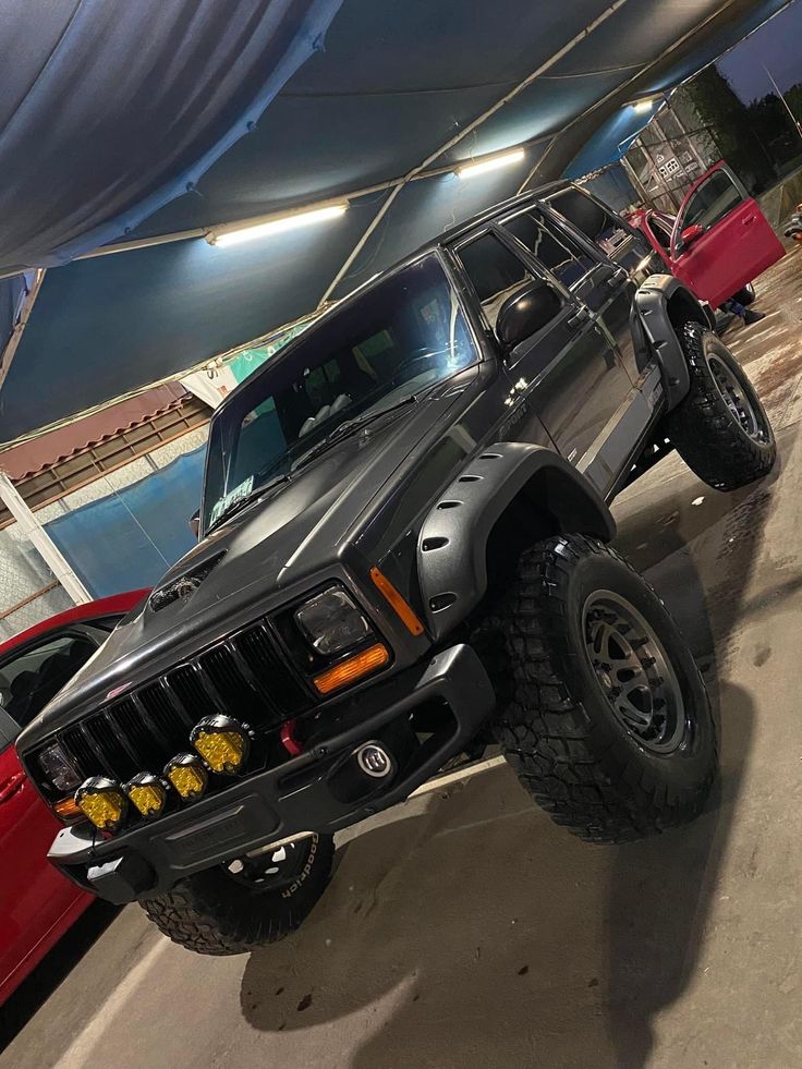 a black jeep parked under a tent in a parking lot