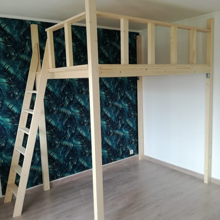 there is a loft bed with a ladder on the bottom and a blue wall behind it