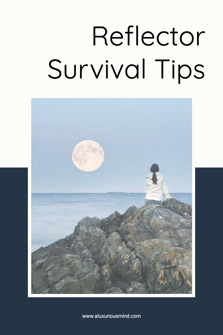 a woman sitting on top of a rock next to the ocean under a full moon