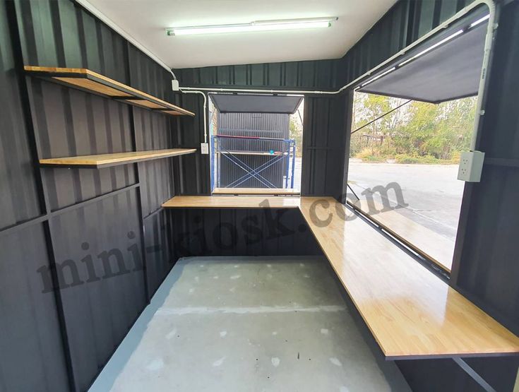 the inside of a storage room with wooden shelves and black paint on the walls is empty