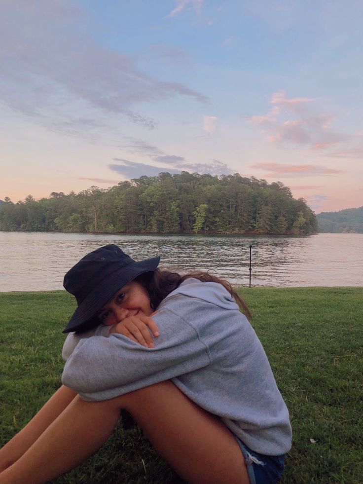 a woman sitting in the grass with her head on her hands