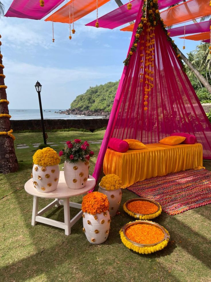 an outdoor area with flowers and decorations on the ground, including a canopy bed covered in orange fabric