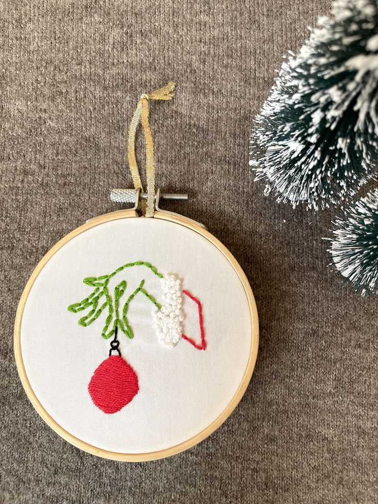 a christmas ornament hanging from the side of a fir tree next to a needle