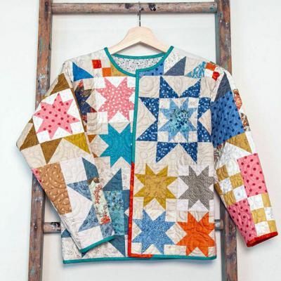 a quilted jacket is hanging on a ladder and it has stars all over it