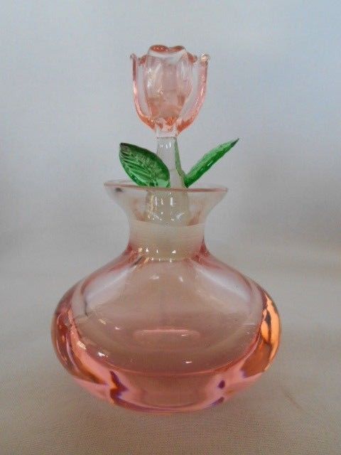 a pink glass vase with a single flower in it