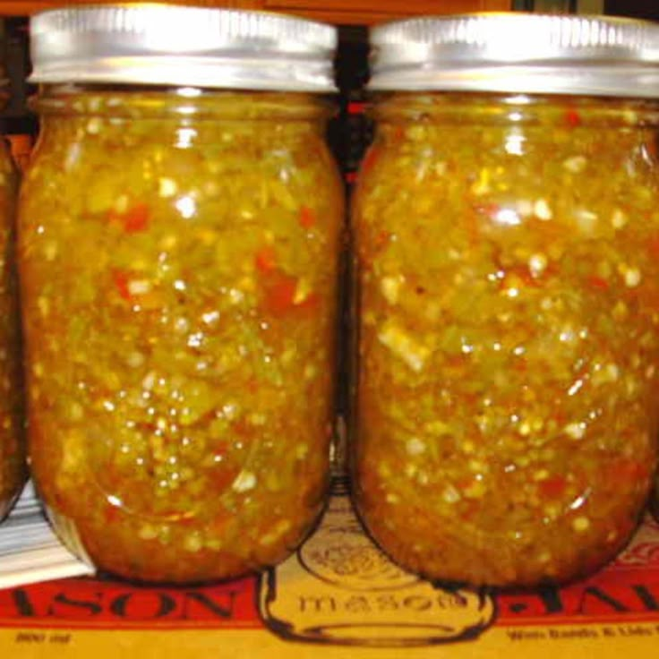 three jars filled with pickles sitting on top of a table