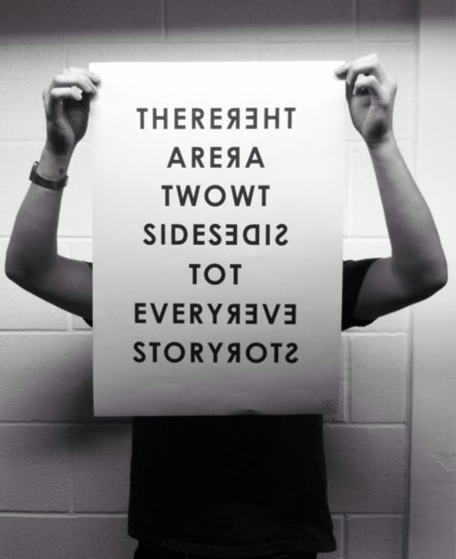 a person holding up a sign that says there are two sides to everyone's story