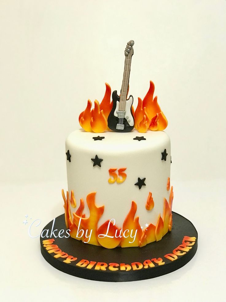 a white cake with flames and a guitar on top