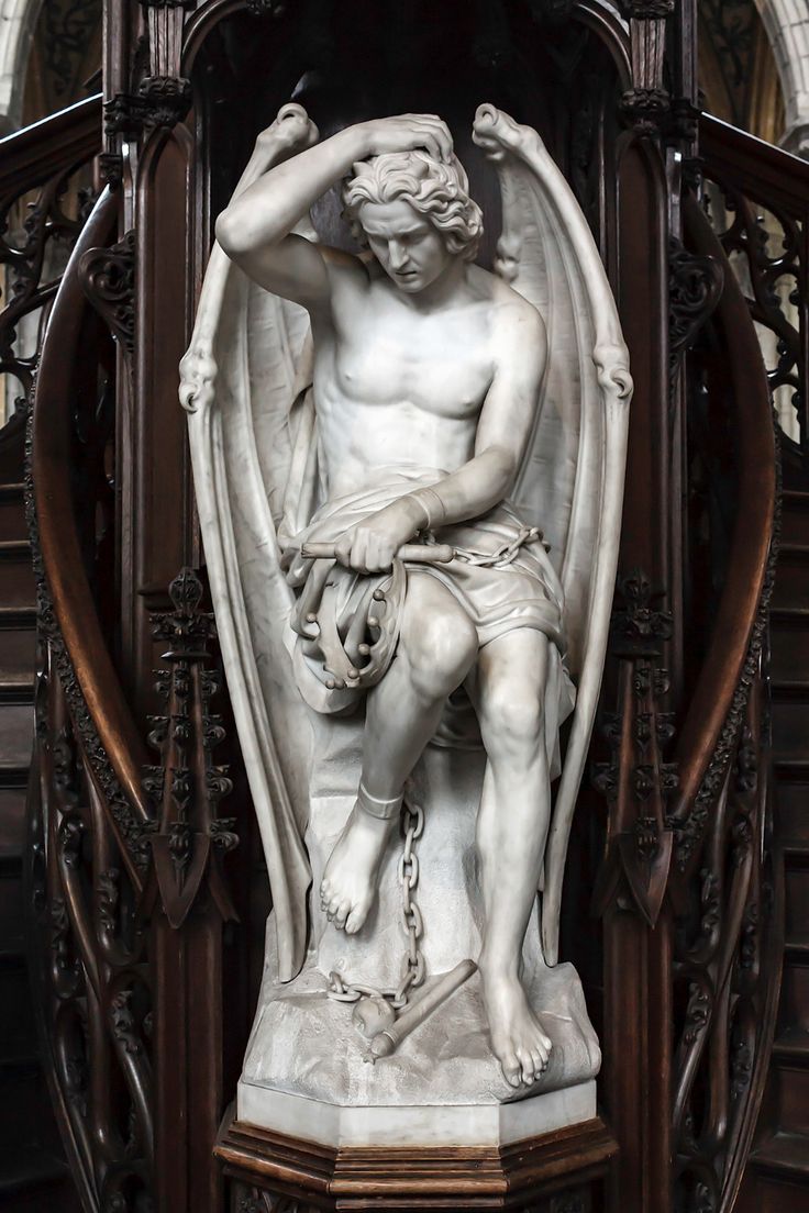 a statue of a man sitting on top of a chair next to a stair case