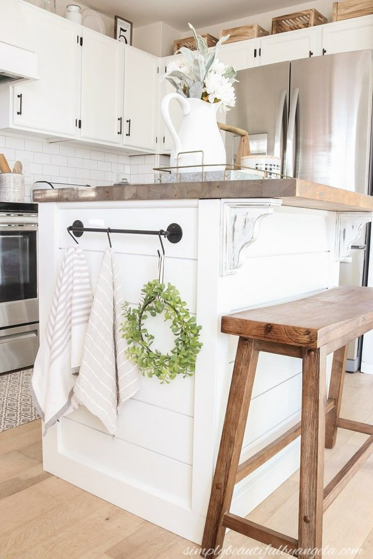 a kitchen with white cabinets and wooden stools